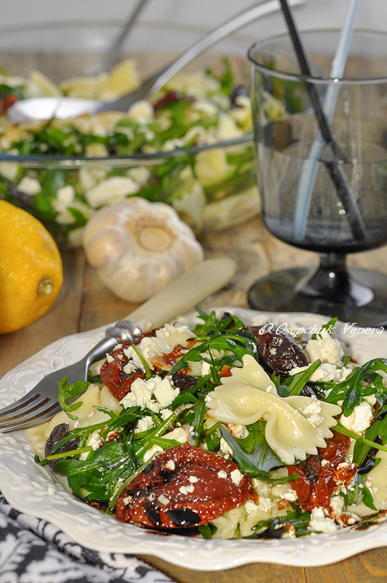 Фото к рецепту: Салат-фарфалле с рукколой, козьим сыром и вялеными томатами с чесночным соусом.