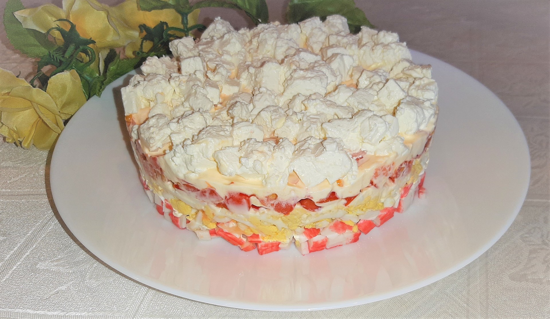 Фото к рецепту: Слоеный салат с крабовыми палочками, помидорами и сыром фета